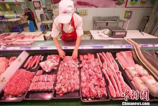 资料图：山西太原，超市员工在整理猪肉。张云 摄