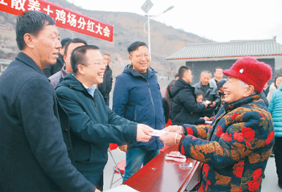 庞泽华（左二）在给村民分红。