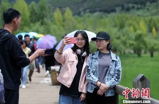资料图： 2019年7月，泸沽湖旁的学生游客。　王磊 摄
