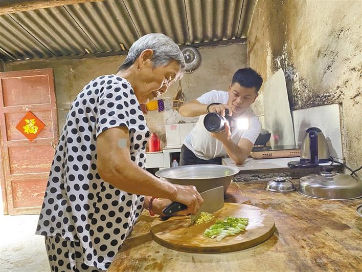 73岁的网络<strong></strong>陈桂刚做饭时，孙子张万露在一旁精心拍摄。秦巴奶奶 记者 马黎摄