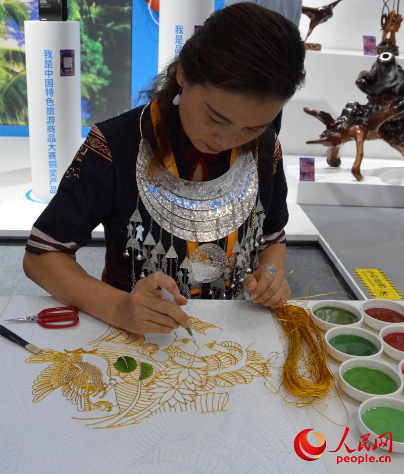 消博会海南馆内，工艺美术师正在绘制景泰蓝掐丝珐琅画。首届人民网记者 杜燕飞摄