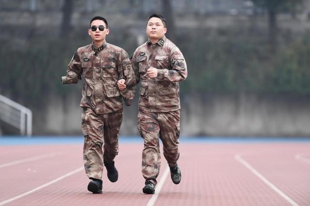“排雷英雄战士”杜富国（左）和战友在陆军军医大学操场上跑步。新华社记者 王全超摄