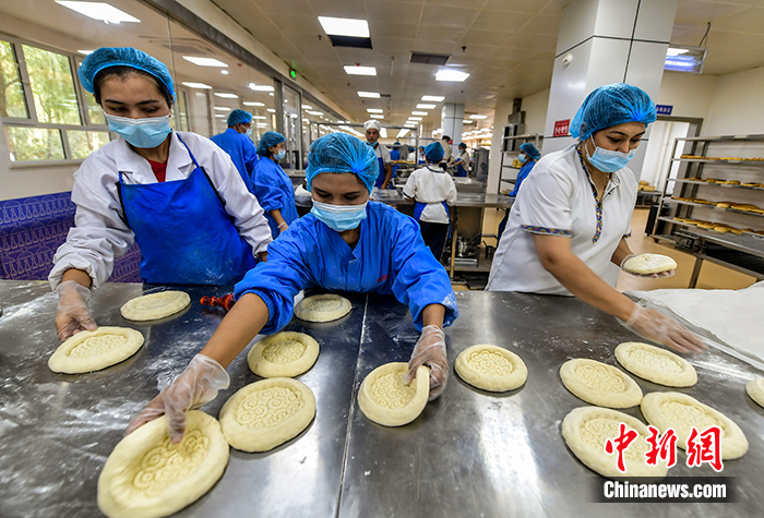 图为9月28日，塞外疆馕文化小镇生产加工车间里，员工正在加工、烤制各种馕产品。 <a target='_blank' href='http://www.chinanews.com/'>中新社</a>记者 刘新 摄