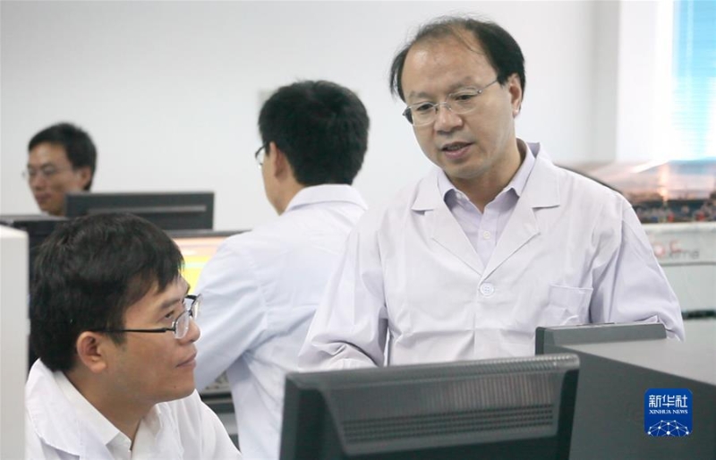 王双飞（右一）在实验室和团队交流（资料照片）。 新华社发