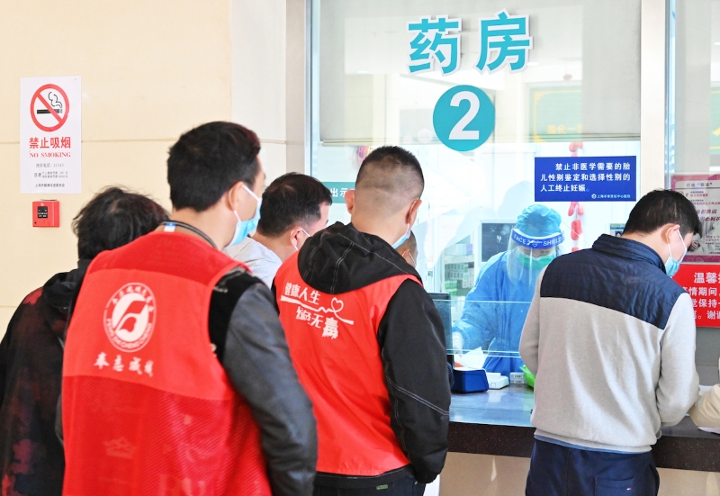 2022年4月18日，上海，奉贤区中心医院，药房工作人员正在取药，志愿者前来统一为居民代配药。