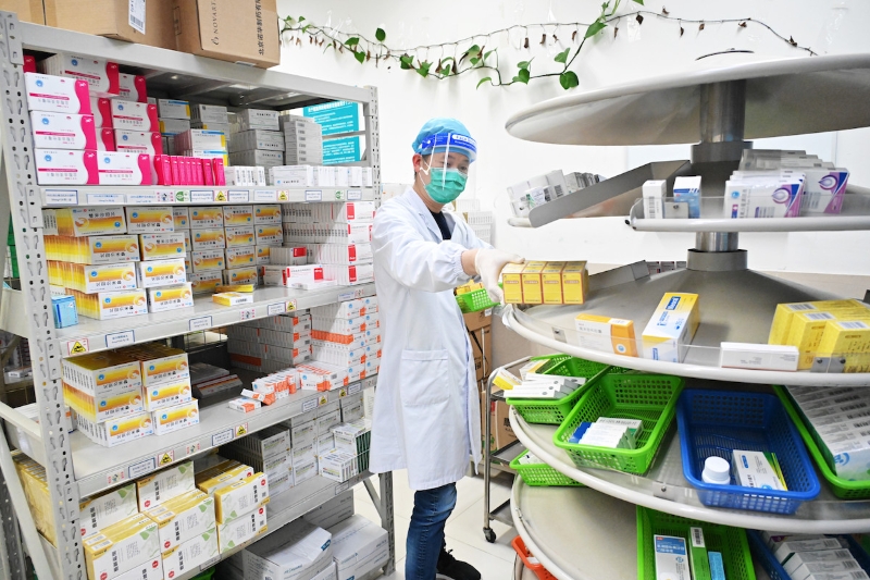 2022年4月18日，上海，奉贤区中心医院，药房工作人员正在取药，志愿者前来统一为居民代配药。