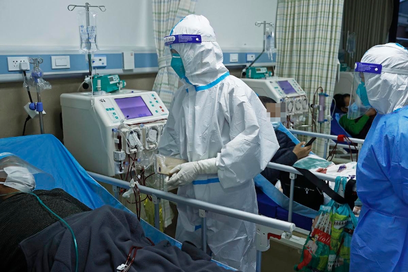2022年4月14日，在临时改建的上海浦东医院曹路透析中心，浙江援沪医疗队医护人员在病房内查看血液透析病人身体状况。
