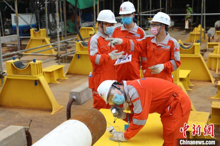 2020年8月27日，青年员工在船体上方检查验收天然气管线，确保管线内部结构完好。　中国海油海南分公司供图
