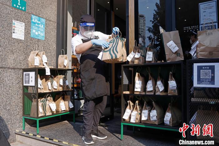 在上海市徐汇区华山路淮海西路口的星巴克门店，工作人员正在将打包好的咖啡摆放至室外指定区域。 殷立勤 摄