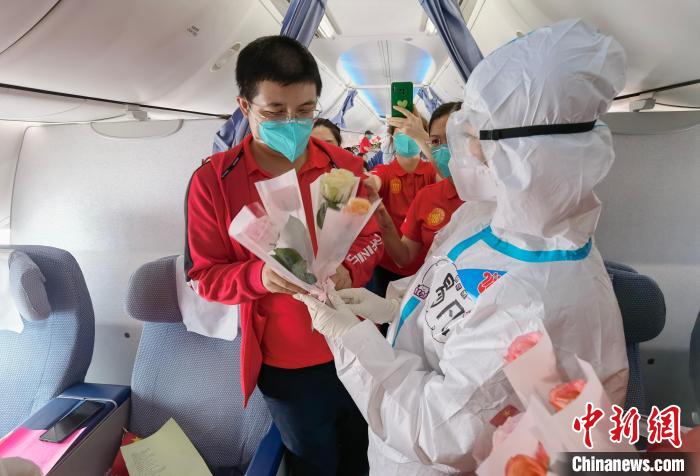 南航乘务人员向每一位医疗队员赠予鲜花。　张瞳 摄