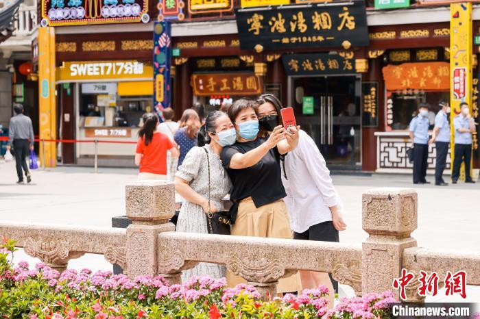 在上海豫园商城，市民在九曲桥广场拍照留念。　上海豫园商城 供图