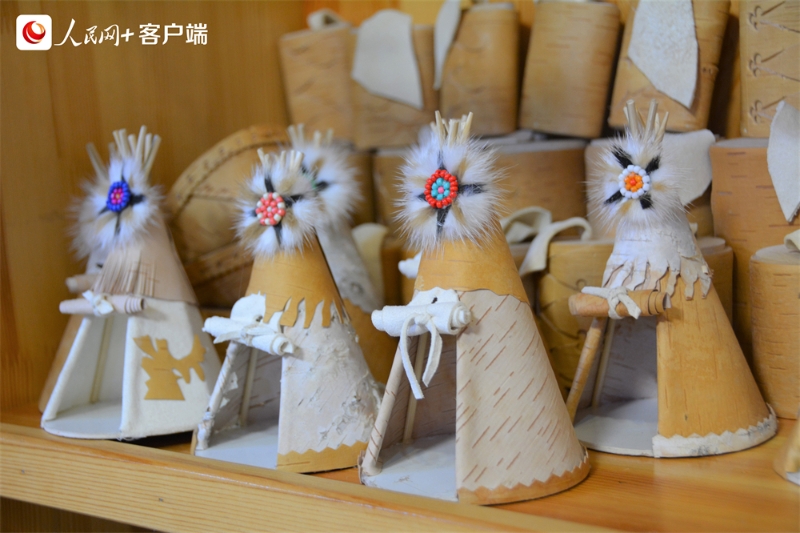 当地妇女使用皮毛和白桦树皮等手工制作的鄂温克族传统民居“撮罗子”摆件。人民网孟丽媛摄