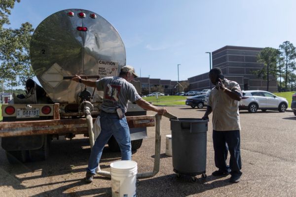 8月31日，杰克逊市一名工人从水罐车为前来的居民供水。（路透社）