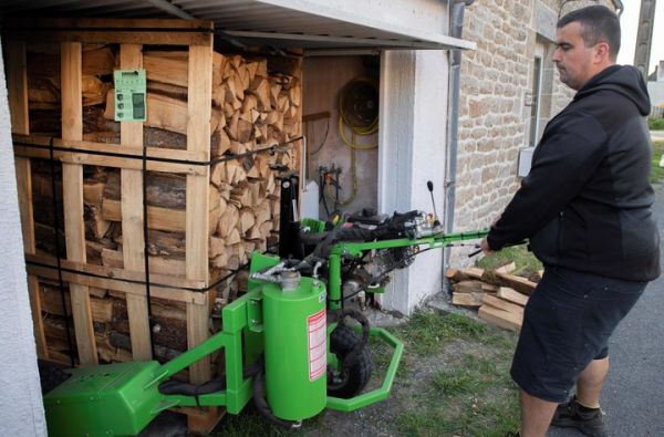 21日，法国一家能源公司的员工在为客户送木柴。（法新社）