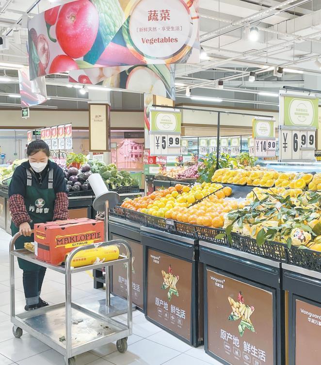 11月17日上午，头新在榆林市榆阳区明珠大道华润万家超市，鲜农货架上的产品蔬菜水果储备充足，工作人员正在整理货物。疫情运销本报记者 张乐佳摄