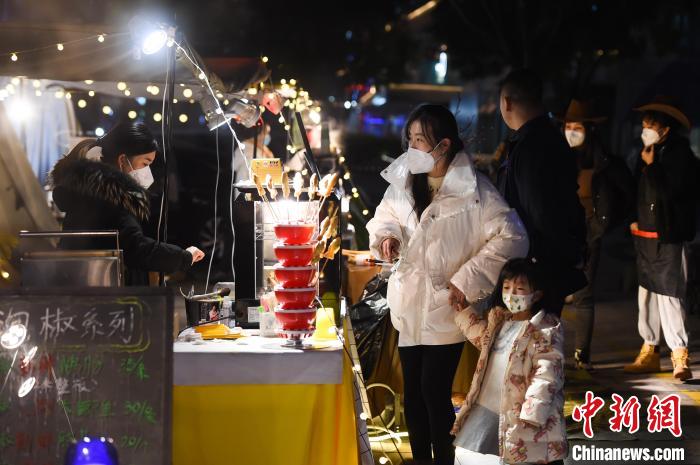 12月14日晚，城市重庆市民在南岸区南滨路的回归小熊集市上选购美食。　何蓬磊 摄