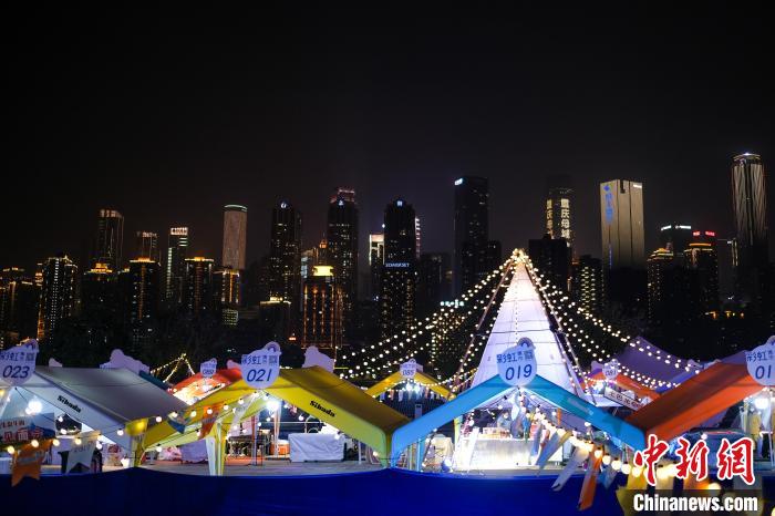 12月14日晚，“彩虹集市”与城市夜景相映成趣。　何蓬磊 摄
