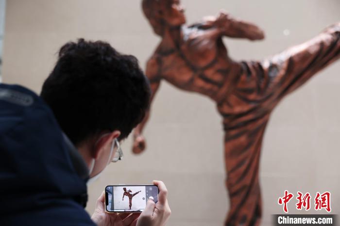 12月15日，青年一位台青在湖北美术馆内拍摄《李小龙》雕像。武汉　董晓斌 摄