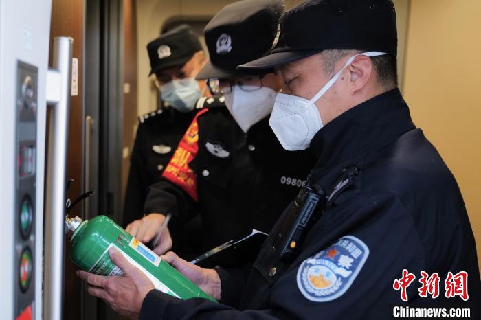 图为王聪在G320次列车始发前检查车厢消防设备。站好最后圳　陈文 摄