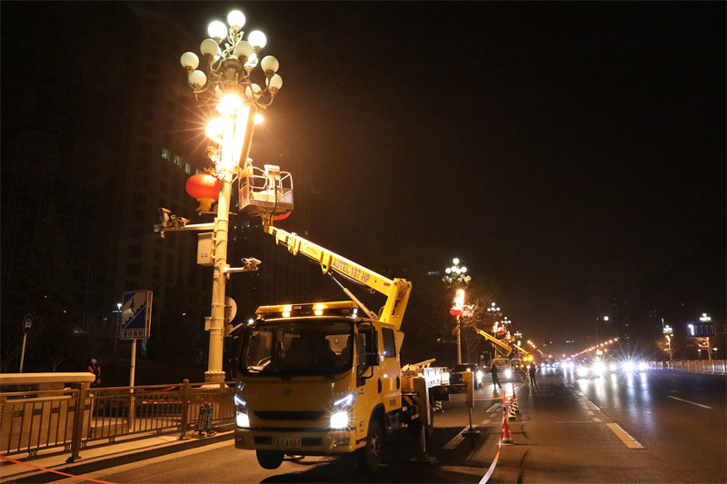 北京电力城市照明管理中心工作人员驾驶高车安装大红灯笼。张超摄