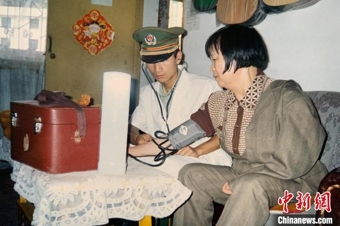2005年4月，中队卫生员到刘玉珍家中为她测量血压。　武警重庆总队执勤第四支队 供图