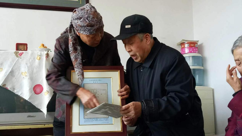 2017年，河北蔚县，王艾甫将烈士王玉山的阵亡通知书交到烈属手中。